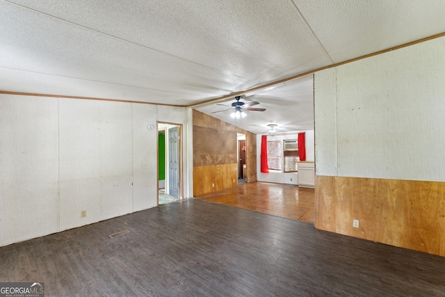 99 Conifer Dr, Guyton, GA 31312 - unfurnished living room featuring ceiling fan, wooden walls, wood finished floors, vaulted ceiling, and a textured ceiling