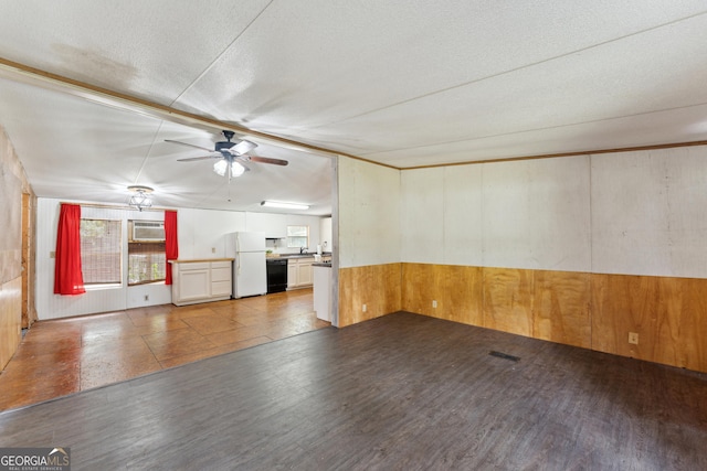 99 Conifer Dr, Guyton, GA 31312 - unfurnished living room featuring wooden walls, a ceiling fan, wood finished floors, a textured ceiling, and a wall mounted air conditioner