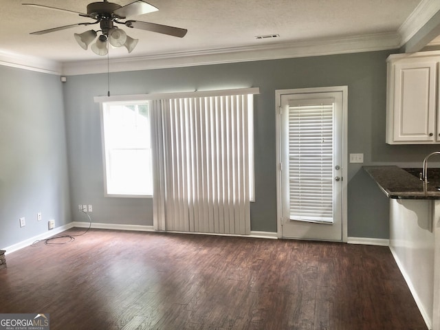 1433 Cotton Trl SW, Conyers, GA 30094 - unfurnished dining area with dark wood-style floors, crown molding, and a ceiling fan