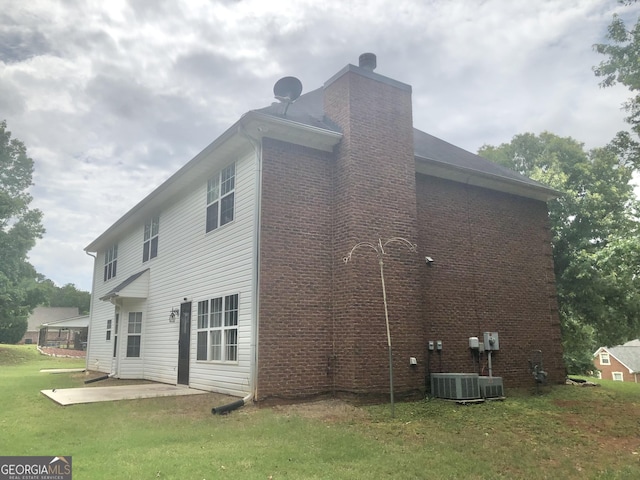 1433 Cotton Trl SW, Conyers, GA 30094 - back of property featuring a patio, a chimney, a lawn, and brick siding