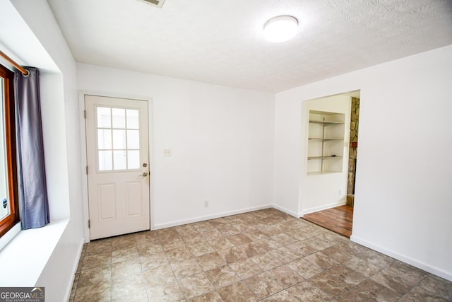 125 Point View Ct, Tyrone, GA 30290 - entryway with stone finish floors, a textured ceiling, and built in shelves