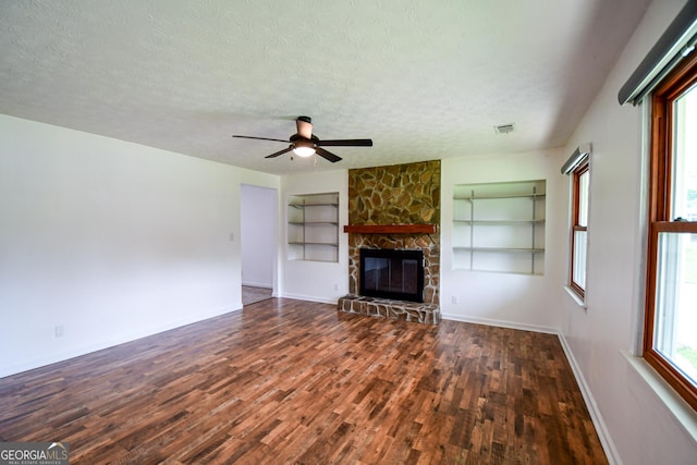 125 Point View Ct, Tyrone, GA 30290 - unfurnished living room featuring built in features, a textured ceiling, wood finished floors, a stone fireplace, and a ceiling fan