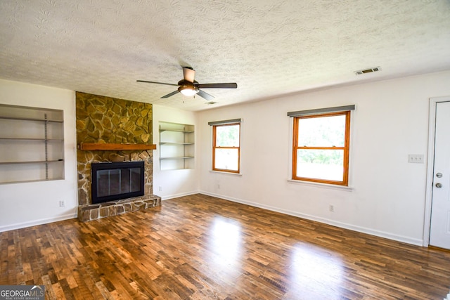 125 Point View Ct, Tyrone, GA 30290 - unfurnished living room with a textured ceiling, built in features, a ceiling fan, wood finished floors, and a stone fireplace