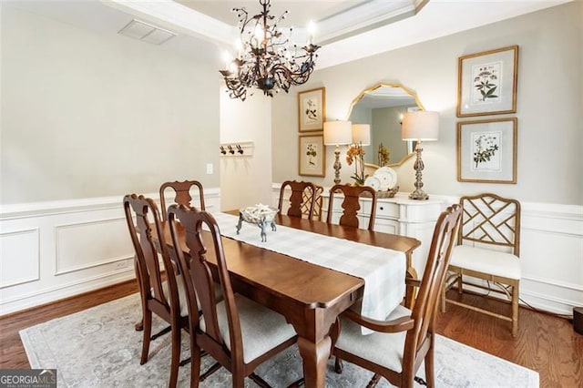 4401 Madison Woods Dr NW Unit 4401, Marietta, GA 30064 - dining space with wood finished floors, a wainscoted wall, a chandelier, a decorative wall, and a tray ceiling