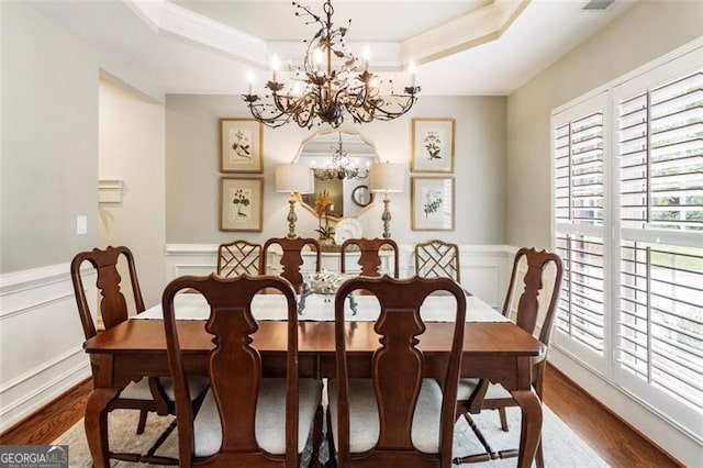 4401 Madison Woods Dr NW Unit 4401, Marietta, GA 30064 - dining space featuring a chandelier, wood finished floors, a tray ceiling, a decorative wall, and a wainscoted wall