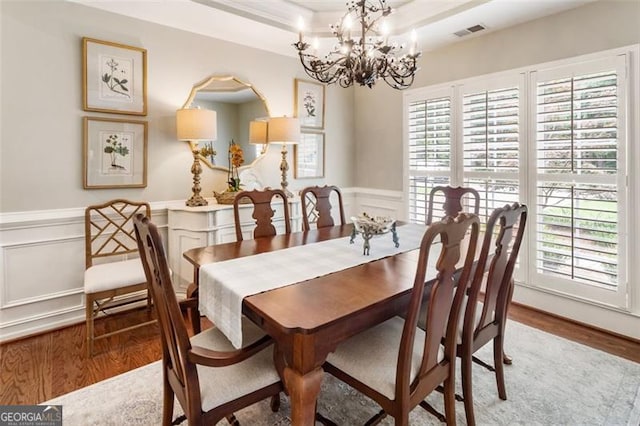 4401 Madison Woods Dr NW Unit 4401, Marietta, GA 30064 - dining area with a chandelier, wood finished floors, a wainscoted wall, a decorative wall, and a raised ceiling