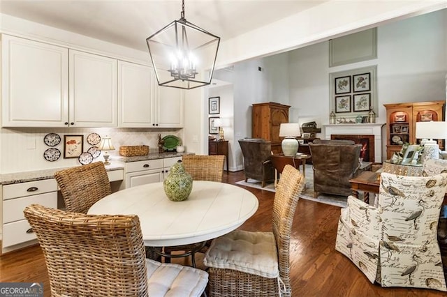 4401 Madison Woods Dr NW Unit 4401, Marietta, GA 30064 - dining area featuring a chandelier, dark wood-style flooring, and a lit fireplace