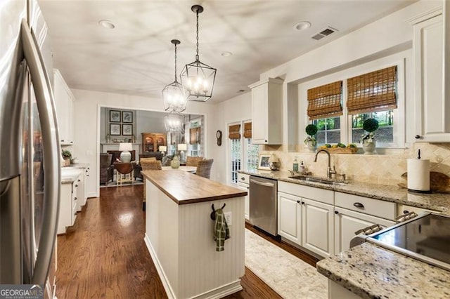 4401 Madison Woods Dr NW Unit 4401, Marietta, GA 30064 - kitchen with stainless steel appliances, butcher block counters, backsplash, a center island, and recessed lighting