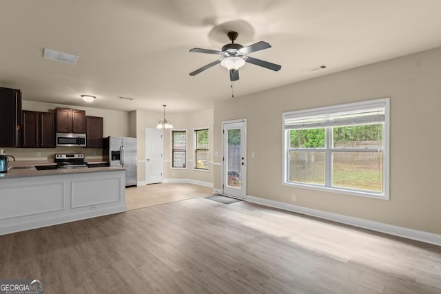127 Kennedy Blvd, Jackson, GA 30233 - kitchen featuring appliances with stainless steel finishes, dark brown cabinets, light wood-style floors, and healthy amount of natural light