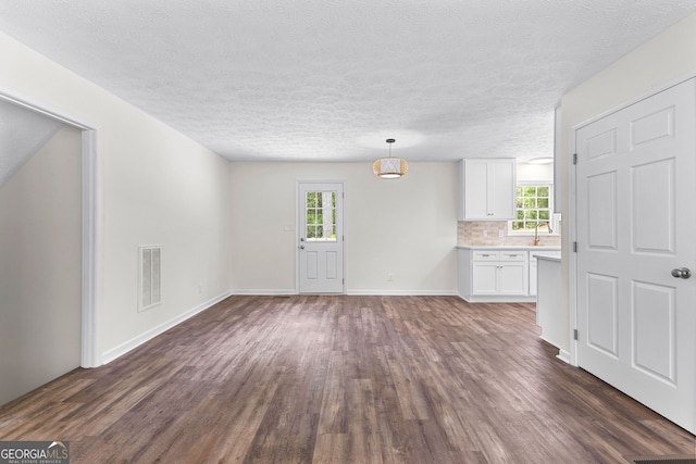 223 Pinehaven Dr, Lagrange, GA 30240 - unfurnished living room featuring dark wood-type flooring, plenty of natural light, and a textured ceiling