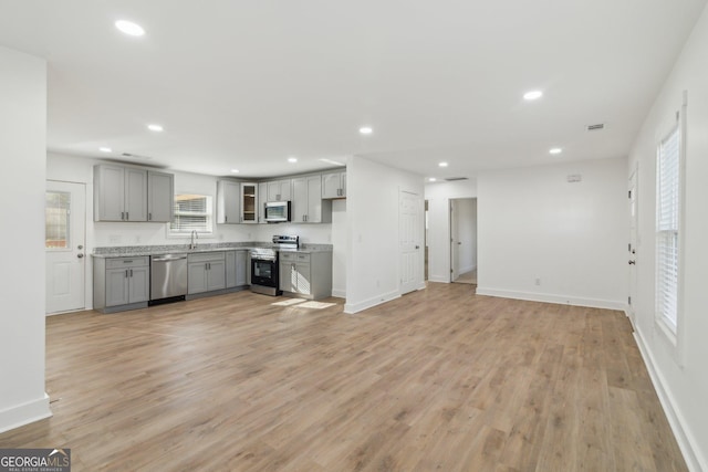 4179 Hanes Dr, Decatur, GA 30035 - kitchen featuring gray cabinets, appliances with stainless steel finishes, recessed lighting, light wood-style floors, and glass insert cabinets