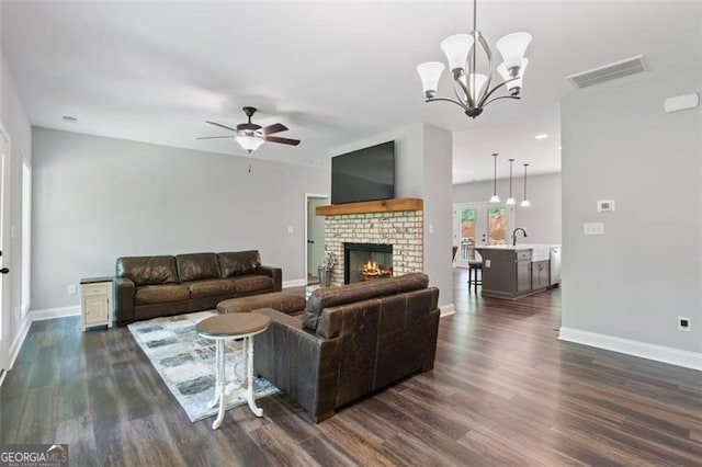 2716 Taylorsville Rd, Taylorsville, GA 30178 - living area with dark wood-style flooring, a ceiling fan, a brick fireplace, and a chandelier