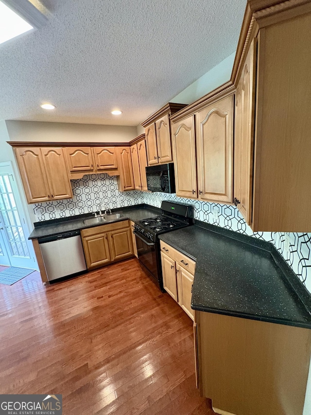 237 Shockley Way, Dallas, GA 30157 - kitchen featuring black appliances, wood finished floors, dark countertops, tasteful backsplash, and a textured ceiling