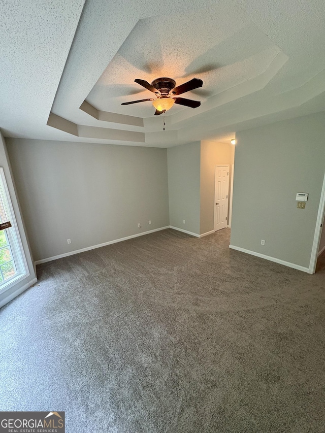 237 Shockley Way, Dallas, GA 30157 - spare room with a tray ceiling, a textured ceiling, a ceiling fan, and dark colored carpet