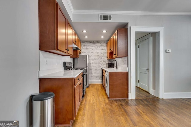 733 Frederica St NE Unit 7, Atlanta, GA 30306 - kitchen with stove, light countertops, under cabinet range hood, wood finished floors, and ornamental molding