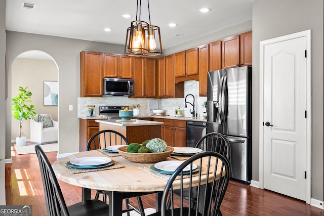 51 Stonebridge Way, Newnan, GA 30265 - kitchen featuring stainless steel appliances, tasteful backsplash, brown cabinets, light countertops, and a kitchen island