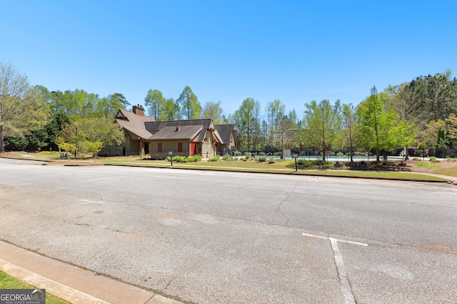 51 Stonebridge Way, Newnan, GA 30265 - view of asphalt street featuring curbs, sidewalks, and view of wooded area