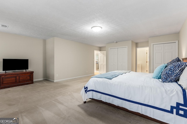 2240 Six Branches Dr, Roswell, GA 30076 - carpeted bedroom featuring multiple closets and a textured ceiling