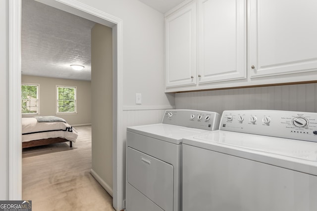 2240 Six Branches Dr, Roswell, GA 30076 - laundry area with independent washer and dryer, cabinet space, light colored carpet, and a textured ceiling