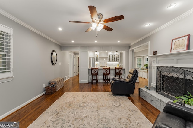 2240 Six Branches Dr, Roswell, GA 30076 - living area with crown molding, ceiling fan, dark wood-style flooring, recessed lighting, and a fireplace with raised hearth