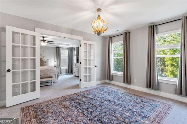 338 Boundless Ln, Canton, GA 30114 - carpeted empty room with french doors, a chandelier, and a ceiling fan
