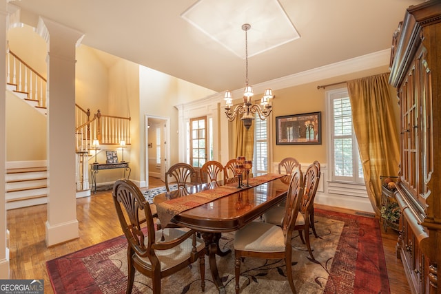 2403 Wistful Way, Marietta, GA 30066 - dining room featuring stairs, a chandelier, healthy amount of natural light, wood finished floors, and a towering ceiling