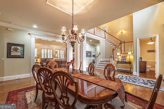 2403 Wistful Way, Marietta, GA 30066 - dining space with wood finished floors, a chandelier, ornamental molding, and stairs