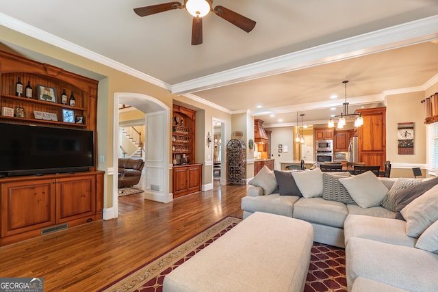 2403 Wistful Way, Marietta, GA 30066 - living area featuring dark wood-style flooring, a ceiling fan, crown molding, stairs, and arched walkways