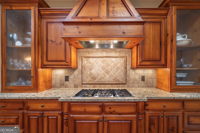 2403 Wistful Way, Marietta, GA 30066 - kitchen featuring stainless steel gas stovetop, brown cabinetry, decorative backsplash, and glass insert cabinets