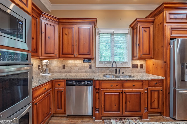 2403 Wistful Way, Marietta, GA 30066 - kitchen with stainless steel appliances, brown cabinets, light stone counters, and ornamental molding