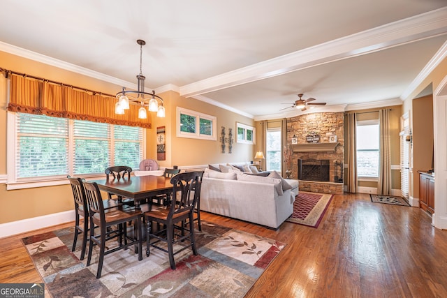 2403 Wistful Way, Marietta, GA 30066 - dining room featuring wood finished floors, a chandelier, a stone fireplace, crown molding, and ceiling fan