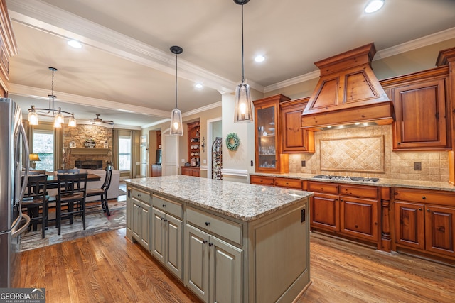 2403 Wistful Way, Marietta, GA 30066 - kitchen featuring appliances with stainless steel finishes, custom range hood, wood finished floors, brown cabinetry, and crown molding