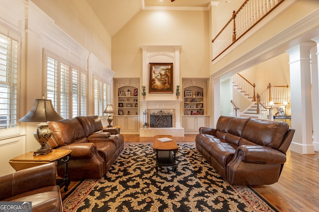 2403 Wistful Way, Marietta, GA 30066 - living area featuring wood finished floors, high vaulted ceiling, stairway, built in shelves, and a high end fireplace