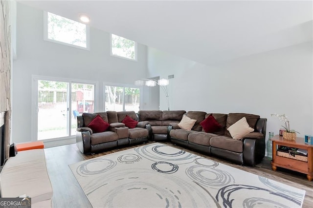 4180 Pineset Dr, Alpharetta, GA 30022 - living room featuring wood finished floors, a towering ceiling, and a fireplace