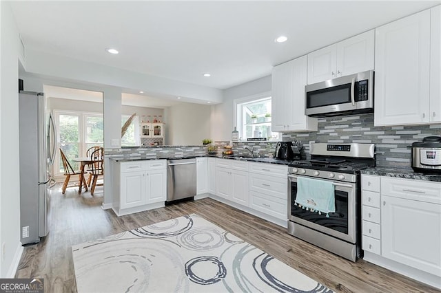 4180 Pineset Dr, Alpharetta, GA 30022 - kitchen with appliances with stainless steel finishes, white cabinetry, backsplash, dark stone countertops, and recessed lighting