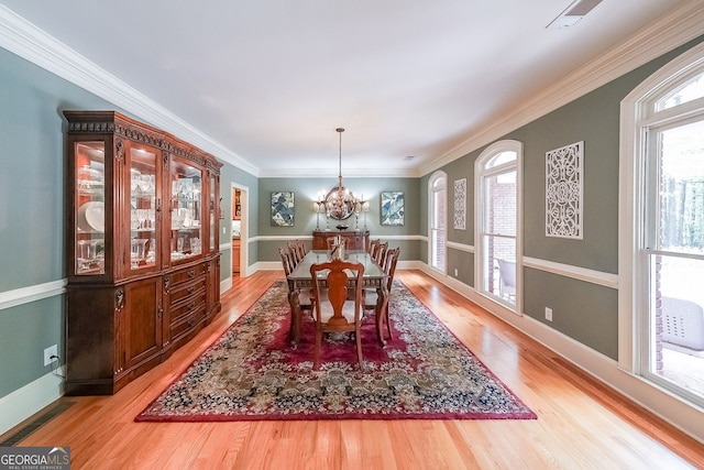 750 Old Loganville Rd SW, Loganville, GA 30052 - dining room with light wood-style floors, a chandelier, and ornamental molding