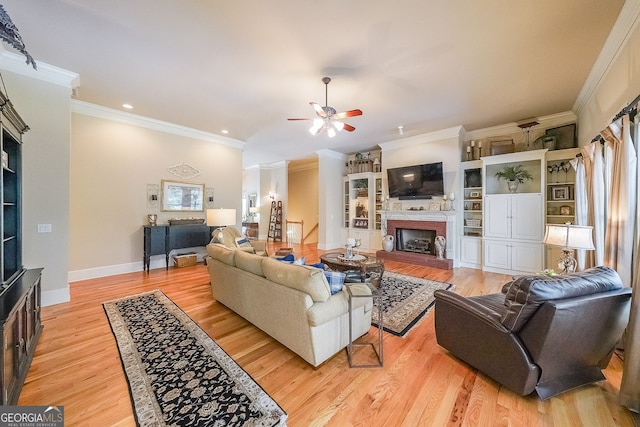 750 Old Loganville Rd SW, Loganville, GA 30052 - living area with a fireplace with raised hearth, ceiling fan, ornamental molding, light wood-style flooring, and recessed lighting
