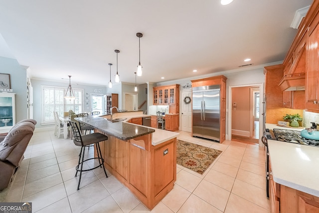 750 Old Loganville Rd SW, Loganville, GA 30052 - kitchen featuring stainless steel appliances, crown molding, light tile patterned floors, a kitchen bar, and a large island