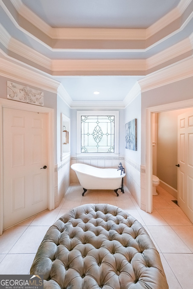 750 Old Loganville Rd SW, Loganville, GA 30052 - bathroom with crown molding, a freestanding bath, a wainscoted wall, tile walls, and tile patterned flooring