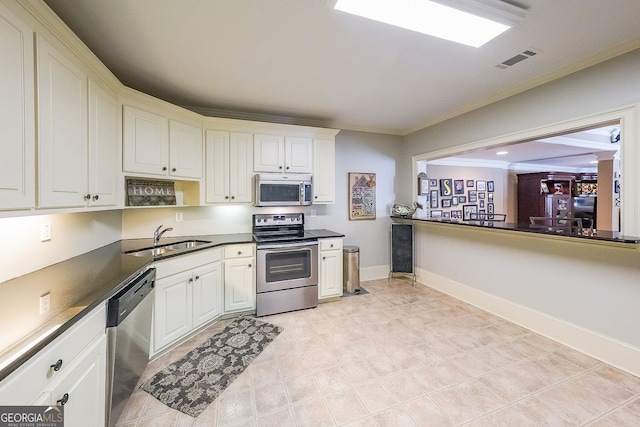 750 Old Loganville Rd SW, Loganville, GA 30052 - kitchen with stainless steel appliances, dark countertops, ornamental molding, and white cabinetry