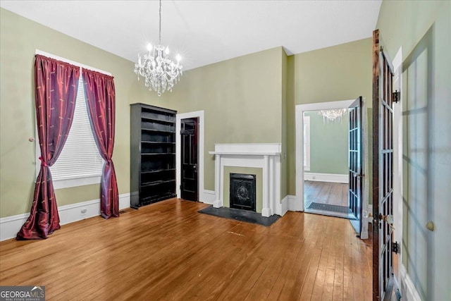 226 Noyes St, Cedartown, GA 30125 - unfurnished living room with hardwood / wood-style floors, a chandelier, and a fireplace with flush hearth