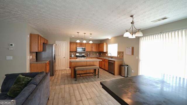 400 Silver Spring St, Dallas, GA 30157 - kitchen featuring appliances with stainless steel finishes, open floor plan, a kitchen breakfast bar, decorative backsplash, and light wood-type flooring