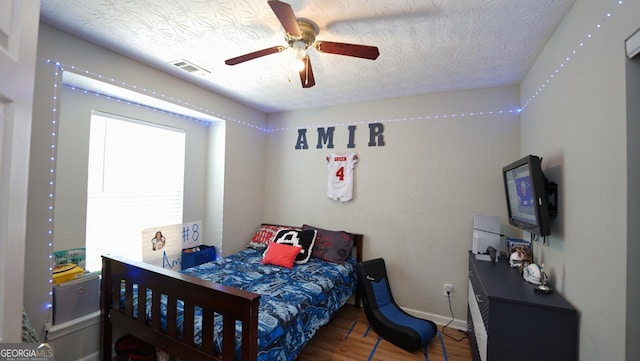 400 Silver Spring St, Dallas, GA 30157 - bedroom featuring wood finished floors, ceiling fan, a textured ceiling, and an AC wall unit