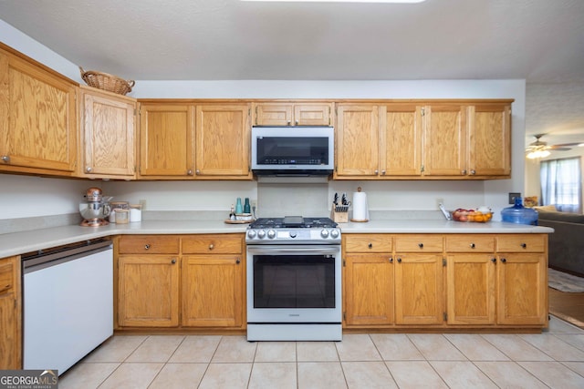 1101 Moon Rd, Shiloh, GA 31826 - kitchen with appliances with stainless steel finishes, light countertops, light tile patterned flooring, and brown cabinetry