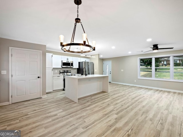 2308 Mark Trl, Decatur, GA 30032 - kitchen featuring appliances with stainless steel finishes, a chandelier, light wood finished floors, open floor plan, and white cabinetry