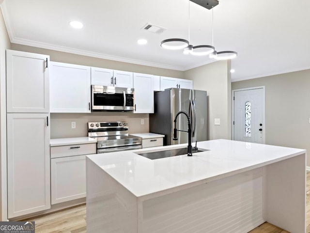 2308 Mark Trl, Decatur, GA 30032 - kitchen with stainless steel appliances, an island with sink, ornamental molding, light countertops, and white cabinetry