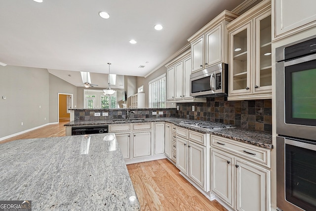 6722 Blue Heron Way, Flowery Branch, GA 30542 - kitchen with appliances with stainless steel finishes, backsplash, a peninsula, light wood-style floors, and dark stone countertops