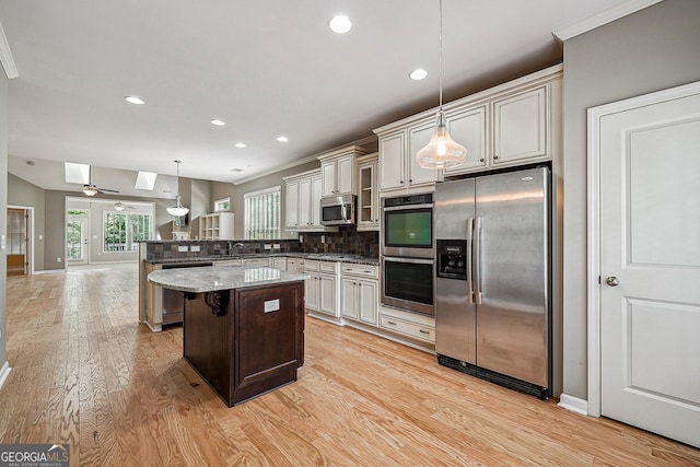 6722 Blue Heron Way, Flowery Branch, GA 30542 - kitchen with stainless steel appliances, light wood-style floors, a peninsula, decorative backsplash, and a breakfast bar
