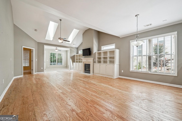 6722 Blue Heron Way, Flowery Branch, GA 30542 - unfurnished living room with wood finished floors, a fireplace with flush hearth, a skylight, ceiling fan, and high vaulted ceiling