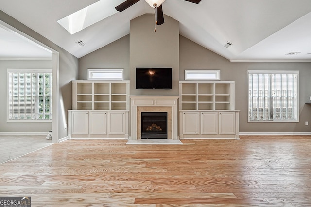 6722 Blue Heron Way, Flowery Branch, GA 30542 - unfurnished living room with a skylight, lofted ceiling, ceiling fan, a high end fireplace, and wood finished floors